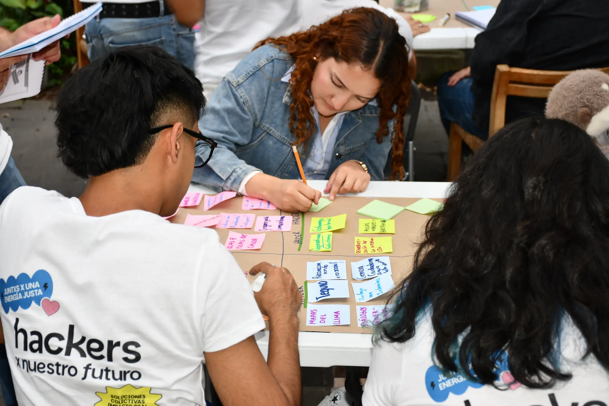 Juventudes escribiendo ideas en notas de colores